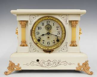 A turn of the century Seth Thomas Beulah model Adamantine mantel clock.  8-day time and strike movement with long alarm, papered metal dial, Arabic numerals, embossed bezel.  White Adamantine finish with marbleized detail and columns, gold metal castings.  Case cleaned and polished with slight wear, dial discoloration, castings re-painted, running when cataloged.  10 3/4" high.  ESTIMATE $150-200