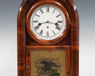 A late 19th century Waterbury Beehive shelf clock.  30-hr spring driven time and strike movement with painted metal dial and Roman numerals.  Molded Mahogany case with shaped door and stenciled Eagle lower glass on a simple plinth base.  Paper label 80% intact.  Refinished with slight wear, re-painted dial, running when cataloged.  18 3/4" high.  ESTIMATE $100-150