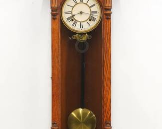 A late 19th century Ansonia Capitol model wall clock.   8-day spring driven time and strike movement, papered metal dial with Arabic numerals.  Oak case features an arched crown with turned finials and cast Liberty mask above an arched door with fluted corned pilasters over a shaped drop with turned finials.  Older refinishing with minor wear, dial wear, most finials are replacements, running when cataloged.  54" high.  ESTIMATE $200-400
