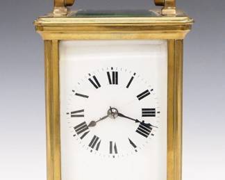 A turn of the century French carriage clock. 8-day time and strike movement with platform escapement and porcelain dial with Roman numerals. Molded Brass case with swing handle and beveled glass panels, hinged rear door. Minor wear, dial hairline, running when cataloged. 6" high overall. ESTIMATE $200-300
