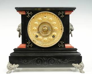 A late 19th century Ansonia La Duchesse model iron mantel clock.  8-day time and strike movement with embossed Brass dial with Arabic numerals.  Black enameled iron case with painted moldings and pewter color Lions mask handles and feet.  Old finish with minor wear, running when cataloged.  10 1/2" high.  ESTIMATE $200-300