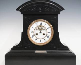 A 19th century French mantel clock by Samuel Marti, Paris.  8-day time and strike movement with visible escapement and two piece White porcelain dial with Roman numerals, serial #316.  Black marble case with an arched top over a corbeled body on a molded plinth base with an 1878 Presentation plaque.  Minor wear, some small edge chips, lacks pendulum not tested.  17" high.  ESTIMATE $300-500