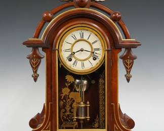 A 19th century Kroeber Albatross model Victorian shelf clock.  8-day time and strike E. N. Welch movement with papered metal dial and Roman numerals.  Walnut case with carved and gilded detail features an arched top with turned finial above an arched door with stenciled glass on a molded base.  Older finish with some wear, some dial wear, running when cataloged.  23 3/4" high.  ESTIMATE $100-150