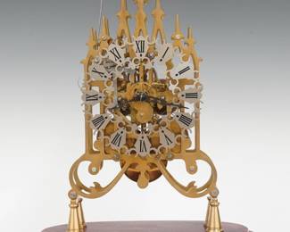 A late 20th century Skeleton clock.  8-day time and strike fusee movement with Silvered filigree dial and Roman numerals with Gothic Revival reticulated Brass plates on a molded wooden base.  Minor wear, running when cataloged.  19" high overall.  ESTIMATE $400-600