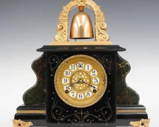 An early 20th century Gilbert Curfew Model mantel clock.  8-day time and strike movement with papered metal dial, fancy sash, Arabic numerals and upper bell strike.  Mixed wood case with Ebonized finish and Marbleized body with gilded detail and cast feet.  Original finish with some wear, running when cataloged.  17 1/4" high overall.  ESTIMATE $100-150