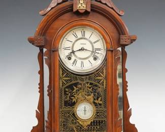A 19th century Kroeber Oregon model shelf clock.  8-day time and strike E. N. Welch movement with papered metal dial and Roman numerals.  Walnut case with carved and gilded detail features an arched top with gilded applique above an arched door with stenciled glass flanked by mirrored pilasters on a rounded base.  Refinished with slight wear, restored dial, running when cataloged.  24" high.  ESTIMATE $200-300