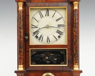 A late 19th century Seth Thomas Mini Column & Cornice shelf clock.  8-day spring driven time and strike movement with painted metal dial and Roman numerals, "S T" hands.  Rosewood case with a molded cornice over single door, clear dial glass and stenciled lower flanked by turned Marbleized columns over a pendulum window with molded Brass bezel on a stepped molded base.  Interior paper label 80% intact.  Refinished with slight wear, dial wear, running when cataloged.  15 3/4" high.  ESTIMATE $100-150