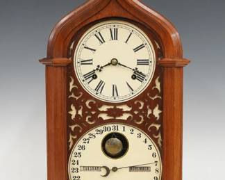 A late 19th century Ithaca Steeple Model Calendar shelf clock.  8-day time and strike movement with lower calendar mechanism and apertures indicating day and month, papered metal dials with Roman/Arabic numerals.  Walnut case with a Gothic arched crest and turned finial over a single long door with pierced carved insert on a molded plinth base.  Refinished with slight wear, re-papered dials, running when cataloged.  25 1/4" high.  ESTIMATE $400-600