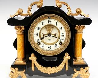 A late 19th century Ansonia Toulon model iron mantel clock.  8-day time and strike movement with visible escapement and two part porcelain dial with Arabic numerals.  Black enameled iron case with two columns and applied Gold painted castings and feet.  Polished finish with slight wear, dial crack and hairlines, running when cataloged.  11" high.  ESTIMATE $200-300
