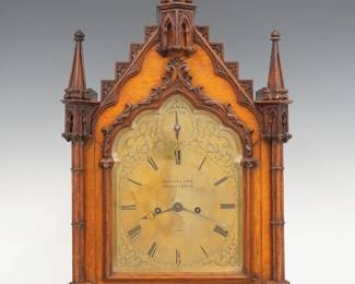 A late 19th century English Gothic Revival Period bracket clock by Barrauld & Lund, Cornhill, London.  8-day spring driven fusee time and strike movement with a shaped Brass dial, scrolled foliate engraving and Roman numerals with upper subsidiary Strike/Silent selector, marked "Barrauld & Lund, Cornhill, London, 1645, additionally signed on the back plate of movement.  Oak case with carved detail features a pediment top with paneled tapering finials over a shaped door with foliate detail flanked by carved colmns and reticulated side panels with Gothic tracery on a paneled base with plinth feet, rear acess door also has reticulated Gothic tracery design.  Original finish with some wear, minor loss to center finial. movement is quite dirty