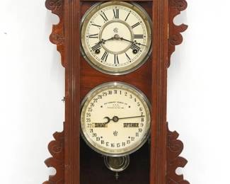 A late 19th century Waterbury No. 38 model wall clock.  8-day time and strike movement with painted metal dials and Roman numerals, lower calendar mechanism with apertures indicating day, month and date.  Walnut case with carved details features a shaped crest over a single door with reeded frame above a shaped bracket drop.  Paper labels on back 80% intact.  Older refinishing with minor wear, running when cataloged.  28" high.  ESTIMATE $300-400