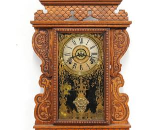 A turn of the century Welch Kitchen wall clock.  8-day time, strike and alarm movement with papered metal dial and Roman numerals.  Oak case with pressed design features a shaped crest over a molded door with stenciled glass above a shaped bracket drop.  Paper label on back 10% intact.  Older refinishing with minor wear, dial wear, running when cataloged.  29" high.  ESTIMATE $100-150