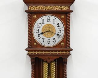 A late 19th century Ansonia Niobe model wall clock. 8-day weight driven time and strike movement, cast metal dial with painted finish and Arabic numerals, fancy cast pendulum bob. Oak case with extensive cast Brass ornamentation features a scrolled crown with Satyr mask and turned finial over a cast foliate frieze and open dial with cast spandrels flanked by rope twist columns over an open well with filigree brackets, rope twist columns and a shaped drop. Refinished with minor wear, paint touchups, running when cataloged. 45" high plus weight drop. ESTIMATE $800-1,200