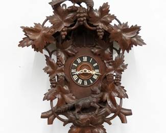 An early 20th century German Black Forest Cuckoo wall clock.  30-hr Brass time and strike three weight movement with Cuckoo, Quail and Gong strike, wooden dial with applied Roman numerals.  Walnut case with carved detail features a Raven crest over a body with Fox and Grapes motif on dial surround.  Original finish with minor wear, running when cataloged.  28 1/2" high plus weight drop.  ESTIMATE $400-600