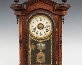 A 19th century E. N. Welch Lucca model Victorian shelf clock.  8-day time, strike and alarm movement with painted metal dial and Roman numerals, fancy pendulum with glass insert.  Rosewood case with molded pediment top and turned finials above a single arched door with stenciled glass, flanked by applied pilasters on a molded base.  Paper label on back fragment only.  Older finish with minor wear, re-painted dial, running when cataloged.   23 1/2" high.  ESTIMATE $300-400
