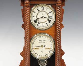 A late 19th century Waterbury No. 40 Model shelf clock.  8-day time and strike movement with lower calendar mechanism and apertures indicating day and month, painted metal dials with Roman/Arabic numerals.  Oak case with carved detail features a scrolled crest above a single door with rope turned pilasters on a molded base.  Paper labels verso 50% intact.  Refinished with slight wear, dial wear and crazing, running when cataloged.  23 3/4" high.  ESTIMATE $300-400