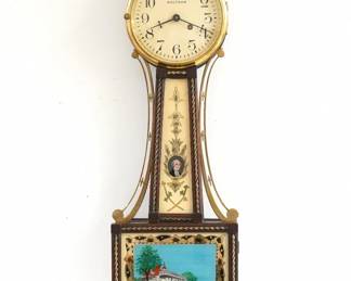 A 1930's miniature Waltham Presentation Banjo clock, Washington/Mt Vernon model. 8-day time only key wind movement with lever escapement and painted dial with Arabic numerals.  Mahogany case with Brass Eagle finial, Brass side arms and rope trim, original reverse painted throat glass and lower glass.  Original finish with wear and crazing, lack rear F/S cover, running when cataloged.  20 3/4" high.  ESTIMATE $100-150