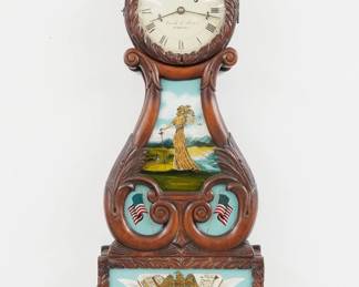 A 1970's Eurich & Romeo, Dearborn, Michigan Bi-Centennial model Lyre banjo clock. Kilbourne & Proctor (marked Eurich & Romeo) 8-day weight driven time only movement with painted metal dial and Roman numerals marked "Eurich & Romeo, Dearborn", with engraved Eagle pendulum, serial #93/500. Massachusetts style carved Mahogany lyre form case with gilded Eagle finial over a carved dial door with clear glass, waist panel and lower door with reverse painted tablets, over a fluted drop with gilded finial. Minor wear, running when cataloged. 40 1/2" high. ESTIMATE $800-1,200