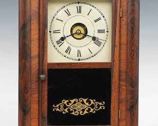 A late 19th century Seth Thomas Mini OG shelf clock.  30-hr spring driven time, strike and alarm movement with painted metal dial and Roman numerals, "S T" hands.  Rosewood case with a single door, clear dial glass and reverse painted lower with gold stencil inside the molded frame.  Interior paper label 80% intact.  Refinished with slight wear, re-painted dial, running when cataloged.  16 1/4" high.  ESTIMATE $100-150