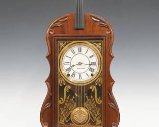 A 1980's Replica Seth Thomas Violin clock, attributed to Tim Davis, Star, NC.  Authentic Seth Thomas Lyre movement, 8-day time and strike with new papered dial and Brass bezel.  Hand crafted Violin Form Mahogany case with upper neck and tuners, above a molded door with stenciled glass, on a molded base with molded 3/4" feet.  Original finish with minor wear, running when cataloged.  30 3/4" high overall.  ESTIMATE $400-600