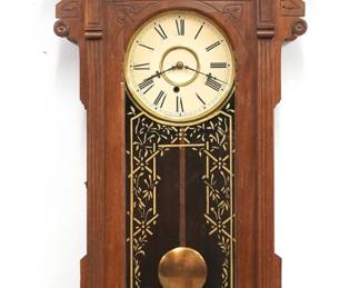 A late 19th century Waterbury Toronto model wall clock.  8-day time only movement with papered metal dial and Roman numerals.  Walnut case with carved detail features a shaped crest over an arched door with stenciled glass over a shaped drop with Burl Walnut detail.  Older refinishing with minor wear, dial re-papered, running when cataloged.  43" high.  ESTIMATE $300-500