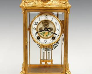 A turn of the century New Haven Thoreau model crystal regulator. 8-day spring driven time and strike movement with two part porcelain dial, visible escapement and Arabic numerals, floral decal and a faux Mercury pendulum. Art Nouveau gilded Brass case with scrolled foliate detail, beveled glass doors and sides on a scrolled base. Minor wear, dial hairlines, running when cataloged. 15" high overall. ESTIMATE $200-300