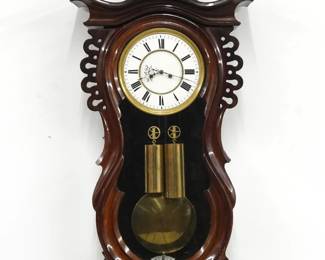 A 19th century two weight Vienna Regulator wall clock.  8-day time and strike movement with two part porcelain dial and Roman numerals within a molded Brass bezel.  Mahogany case with carved detail features a molded crown over a serpentine door shaped lower drop with turned finial.  Old finish with some wear, replaced finial and gold medallion, running when cataloged.  38 3/4" high overall.  ESTIMATE $300-500