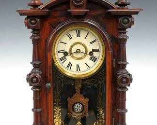 A 19th century E. N. Welch Patti V.P. model Victorian shelf clock. 8-day time and strike movement with painted metal dial and Roman numerals, fancy pendulum with glass insert. Rosewood case with arched top and turned finials above a single long door with stenciled glass, flanked by turned columns on a molded base. Paper label on back 10%. Older finish with minor wear, dial wear, running when cataloged. 19" high. ESTIMATE $400-600