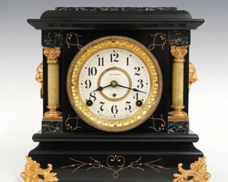 A turn of the century Seth Thomas Adele model Adamantine mantel clock.  8-day time and strike movement with embossed dial and bezel, Arabic numerals.  Black Adamantine finish with marbleized detail and gold metal castings.  Paper label on back 90% intact.  Case cleaned and polished with slight wear, castings re-painted, running when cataloged.  11 1/2" high.  ESTIMATE $150-200