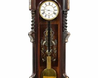 A good 19th century Inlaid Vienna Regulator wall clock.  30-day weight driven time only movement with a two-part porcelain dial, Roman numerals and molded Brass bezel.  Transitional Rosewood case with Brass, Pewter and Abalone marquetry inlay feature an arched molded crown with inlaid panel, above an arched door with spiral columns and molded pilasters with an inlaid back panel over a shaped inlaid drop and lower finial.  Polished finish with minor restoration, faint hairlines in dial, running when cataloged.  62" high overall.   ESTIMATE $3,000-4,000