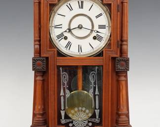 A late 19th century Gilbert Mitra model shelf clock.  8-day time and strike movement with papered metal dial and Roman numerals.  Cherry case with fluted detail features a stepped top above a single door with clear dial glass and stenciled lower in a molded frame flanked by rosettes and turned pilasters on a plinth base.  Refinished with minor wear, re-papered dial, running when cataloged.  22 1/2" high.  ESTIMATE $100-150
