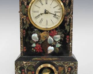 A 19th century Terry & Andrews decorated iron front shelf clock.  8-day Brass time and strike lyre movement with painted Iron dial and Roman numerals.  Iron case with flat top, circular molded Brass dial and lower doors, original Black painted finish with applied Mother-of-Pearl and multicolor painted decoration.  Ansonia paper label inside backboard 70% intact.  Original finish with some wear, dial wear and losses, running when cataloged.  13 3/4" high,  ESTIMATE $100-150
