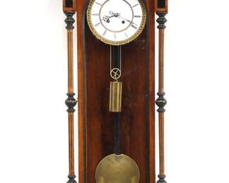 An unusual 19th century Vienna Regulator wall clock.  8-day weight driven time side/spring driven strike side movement with two-part porcelain dial and Roman numerals, within a cast Piecrust  bezel.  Walnut case with Ebonized detail features a shaped crest with carved finial over an arched door with etched glass flanked by carved turned columns and shaped lower drop.  Refinished with minor wear, some restoration, dial chips and hairlines, running when cataloged.  46" high overall.  ESTIMATE $300-500