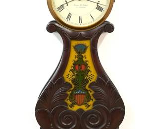 A 20th century Boston Style Lyre banjo clock.  8-day time only movement with painted metal dial and Roman numerals.  Mahogany case with carved foliate detail with a foliate finial over a molded Brass dial door, shaped throat panel with reverse painted glass, lower door with reverse painted glass, over a shaped drop with finial.  Glasses by Tom Moberg.  Original finish with slight wear, running when cataloged.  39" high overall.  ESTIMATE $600-800