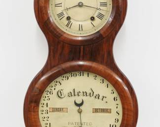 A late 19th century Seth Thomas "Peanut" Office Calendar No. 3 Model wall clock. 8-day time, and strike movement and lower calendar mechanism with apertures indicating day and month, painted metal dials with Roman/Arabic numerals "S T" hands on time dial. Rosewood case with a single door and circular dial glasses. Nicely refinished with slight wear, minor dial wear, running when cataloged. 23 1/2" high. ESTIMATE $2,000-3,000