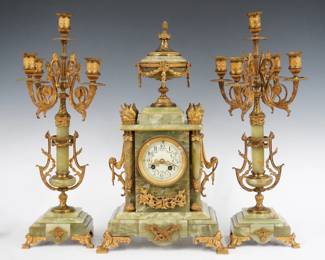 A late 19th century Louis XVI Style French three piece Green Onyx clock set with candelabras by A. D. Mougin, Paris.  8-day time and strike movement with painted convex porcelain dial, Arabic numerals and Fancy gilded filigree hands, serial #1322.  Green Onyx case and candelabra with Gilded metal mounts.  Minor wear, some inclusions and hairlines in the stone, running when cataloged.   Clock 19 3/4" high, candelabra 20 3/4" high.  ESTIMATE $1,000-1,500
