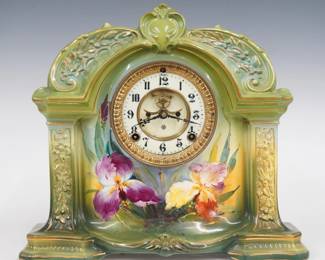 A late 19th century Ansonia La Orb model porcelain shelf clock.  8-day time and strike movement with visible escapement, two part porcelain dial and Roman numerals.  Molded Royal Bonn porcelain case with floral decoration and gilded detail on a Green background.  Minor wear, some crazing, dial hairlines, running when cataloged.  12 1/2" high.  ESTIMATE $200-300