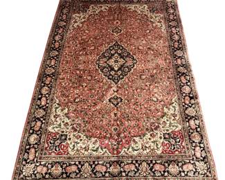 Warm salmon-toned rug with a central medallion and detailed floral border.