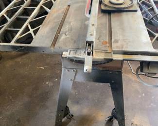 Craftsman table saw on a metal stand with extension wings, rip fence and extra saw blade. Heavy-duty woodworking saw for ripping and crosscutting lumber and sheet material.