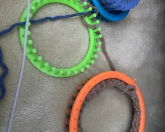 Assorted round knitting looms with yarn and works in progress. Great for making hats, scarves and other yarn crafts.