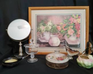 A collection of decorative vanity accessories, glassware, and framed art, perfect