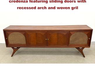 Lot 408 MidCentury Modern walnut console credenza featuring sliding doors with recessed arch and woven gril