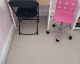 Small desk; pink child's chair; black folding chair
