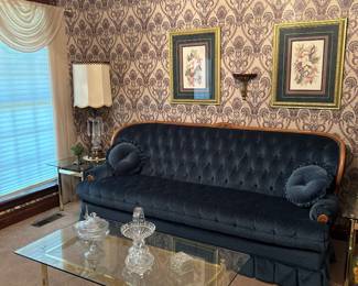 Victorian-style parlor sofa features a deep navy velvet upholstery with tufted backrest, Glass coffee table