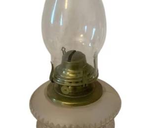 256 - Oil Lamp 22" (Description): Oil lamp measuring 22 inches in height.  Features a clear glass chimney, brass burner  mechanism, white milk glass font with  decorative beaded trim, and a weathered  copper-finished base.