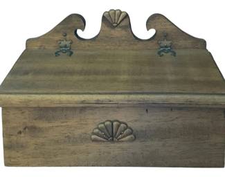 370 - Wood Hanging Storage Box 8.5"x4.5"x6.5" (Description): Wood hanging storage box featuring a  decorative scrolled back with two brass hooks  for wall mounting. The box has a hinged lid  and carved shell motif details. Measures  8.5"x4.5"x6.5".