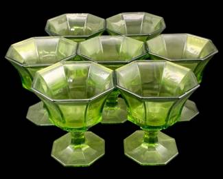 376 - 7 Green Glass Footed Dessert Cups (Description): A seven-piece set of green glass footed  dessert cups. Each cup features a paneled  octagonal design with a pedestal base.  Measurements: 4 inches by 3.5 inches.