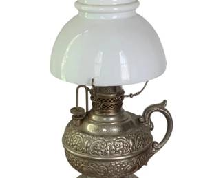 43 - "The Miller" Oil Lamp 13" tall (Description): "The Miller" oil lamp featuring an ornate  embossed metal base with scrollwork design,  decorative handle, and milk glass shade with  clear glass chimney. Measures 13 inches tall.