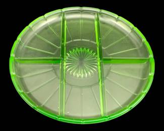397 - Uranium Green Glass Divided Serving Platter (Description): Uranium glass serving platter featuring a  divided design with four sections and a  decorative starburst center pattern. The  vibrant green uranium glass displays the  characteristic glow typical of this collectible Depression-era glassware.  Measures 10 inches round.