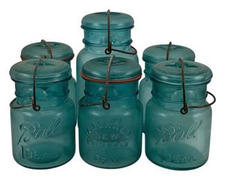 504 - 6 Ball Mason Jars 6", 8" tall (Description): A collection of six vintage Ball mason jars  in the classic blue-green glass. The lot  includes various sizes measuring 6 to 8  inches tall. Jars feature the iconic Ball  Ideal embossed lettering and wire bail closures with glass lids.
